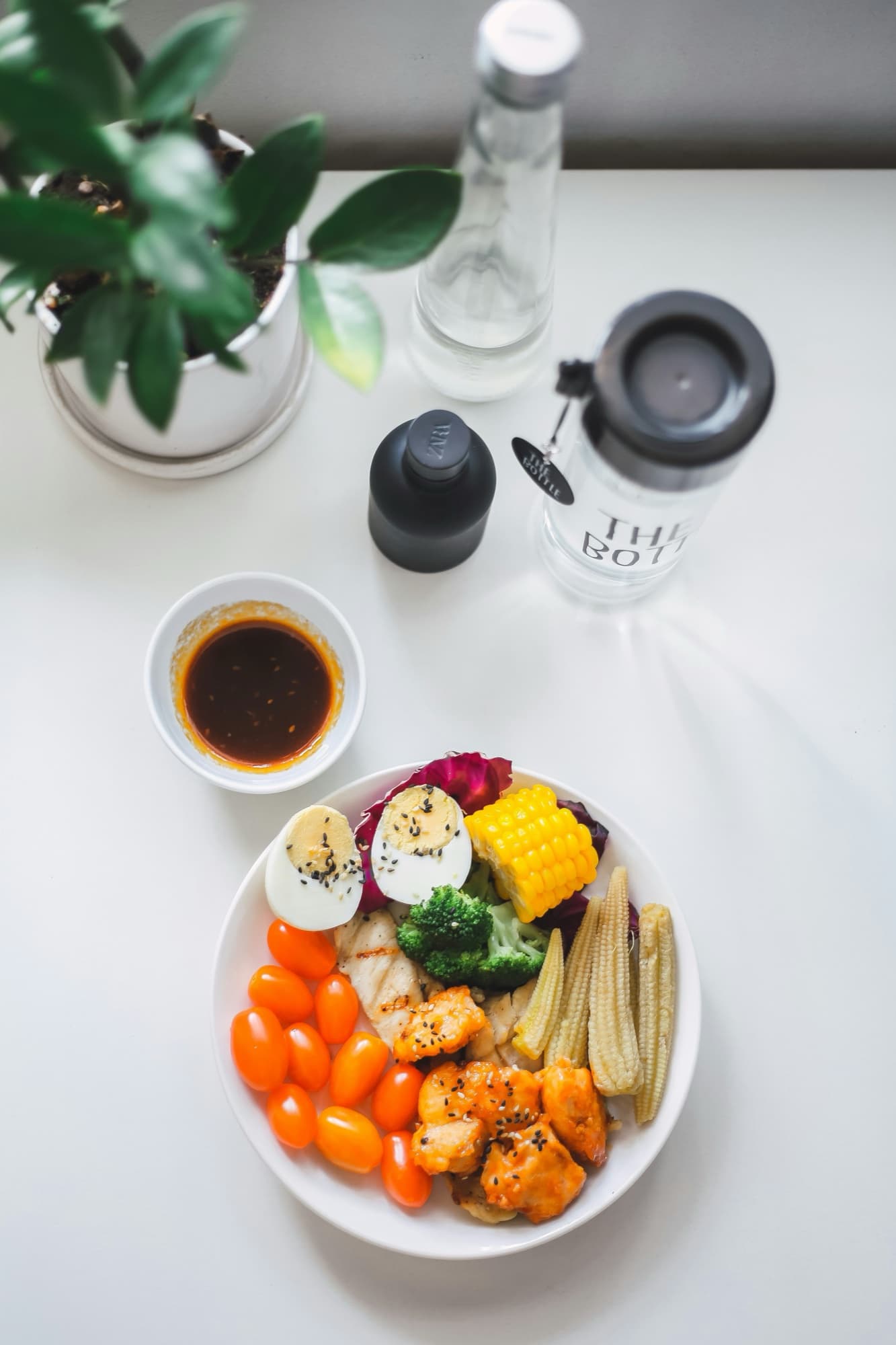 Meal prep containers with protein, rice, and vegetables laid out on a table